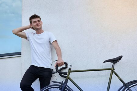 Handsome hipster man posing with bicycle in the city.の写真素材
