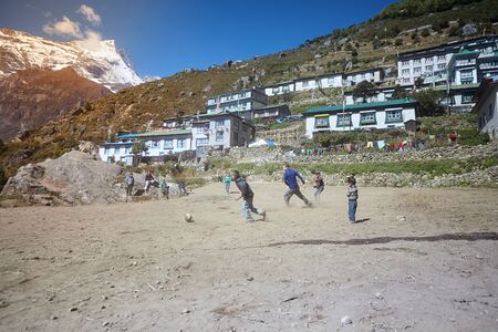 Namche Bazaar, Nepal - October 17, 2015: Unknown children playing football on dusty playground, Namche Bazaarのeditorial素材