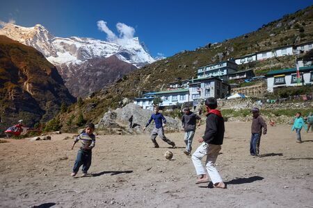 Namche Bazaar, Nepal - October 17, 2015: Unknown children playing football on dusty playground, Namche Bazaarのeditorial素材