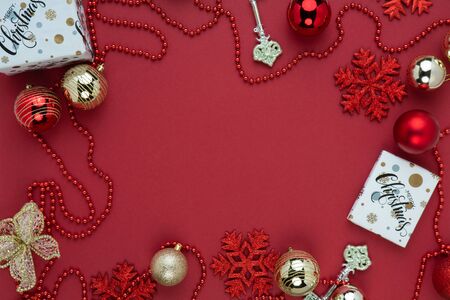 Festive New Year and Christmas picture for banners and greeting cards on a red background. Top view on christmas presents, christmas toys and balls. Image for holiday season and sales.の写真素材