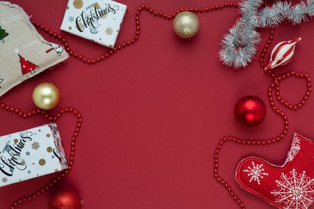 Festive New Year and Christmas picture for banners and greeting cards on a red background. Top view on christmas presents, christmas toys and balls. Image for holiday season and sales.の写真素材