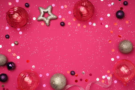 Christmas and New Year composition. Christmas glass decorations on a pink background sprinkled with glitter. Flat layer, top view, copy spaceの写真素材
