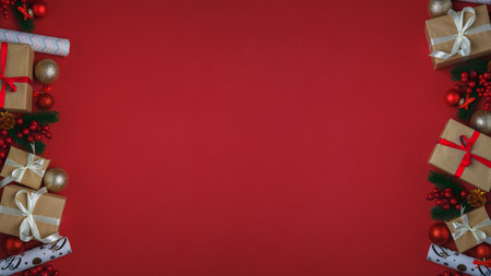 Christmas and New Year background with fir tree and decor. Top view with copy space. Present. Gift boxes, decorations Christmas balls and wrapping paper on red background.の写真素材