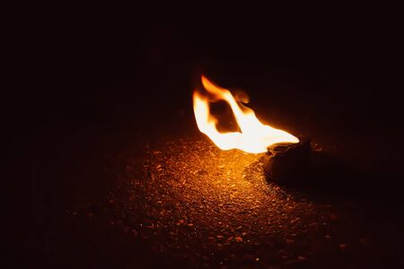 fire burns in a bowl on the groundの写真素材