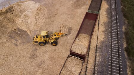the loader loads the sawdust in the woodworking factory aerial view