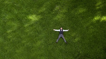 happy presenter with a microphone on the green lawn view from above aerial photography with droneの写真素材
