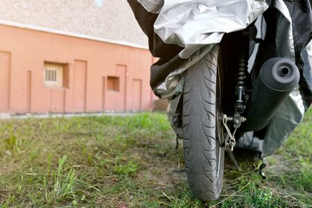 motorcycle under protective cover on the streetの写真素材