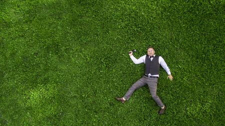 happy presenter with a microphone on the green lawn view from above aerial photography with droneの写真素材