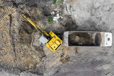 excavator loads sand into the truck top view