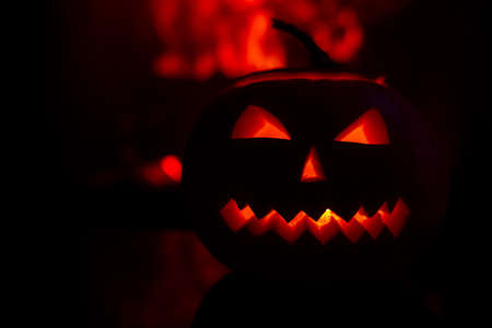 three candles on a black background with a fireplace flame.の写真素材