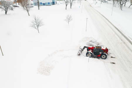 cleaning snow from the streets after a heavy snowfall. Tractor cleans the snow-view from the top.の写真素材
