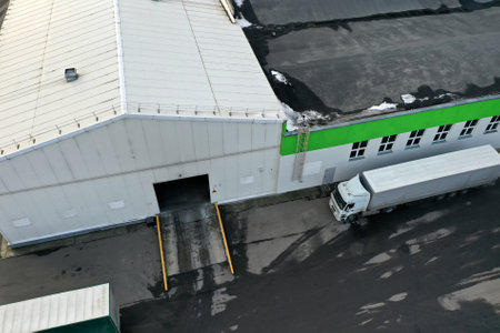 loading trucks with wooden products at the factory aerial view.