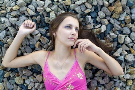 The young woman dreams laying on stonesの写真素材