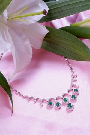 Emerald necklace from white gold and a lilyの写真素材