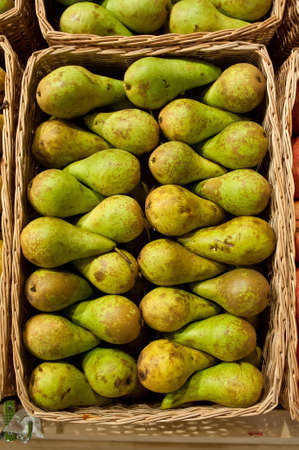 Ripe green pears of a grade in a basketの写真素材