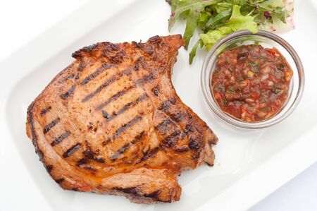 ruddy steak on a white plate with garnish