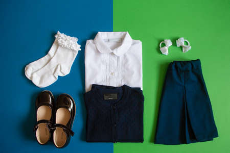 school uniform. Skirt, blouse, jacket, shoes, bows, socks on a green and blue background. Top view.の写真素材