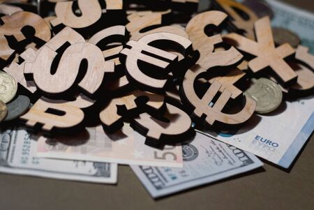 currency icons and real money lie on the desk, background and design for businessの写真素材