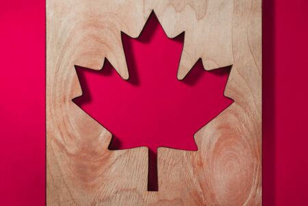 a flag of Canada, a maple leaf carved from a tree on a brightly red background, patriotism and love of one's countryの写真素材