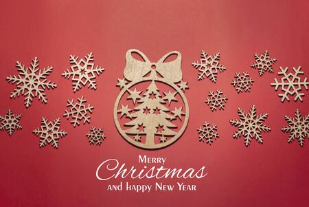 Xmas tree of snowflakes made of wood and white gift, red background, merry Christmas and happy new yearの写真素材