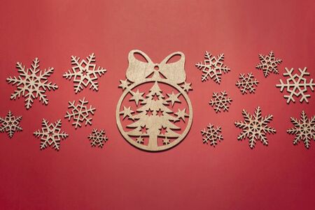 Xmas tree of snowflakes made of wood and white gift, red background, merry Christmas and happy new yearの写真素材