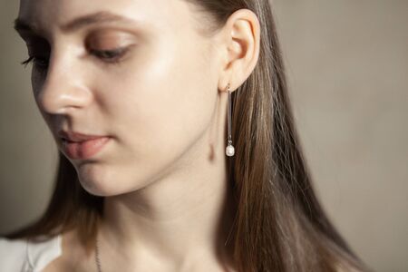 Portrait of beautiful fair young woman with jewelry, one light source