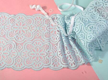 Delicate color laces for panties and bras on pink and blue background with plastic fittings. Elastic...