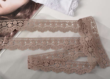 Tapes of black gentle guipure, beauty lace fabric on light background. Elastic material. Using for...