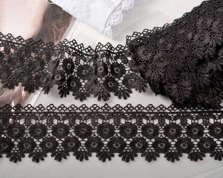 Tapes of black gentle guipure, beauty lace fabric on light background. Elastic material. Using for Atelier and needlework store.の写真素材