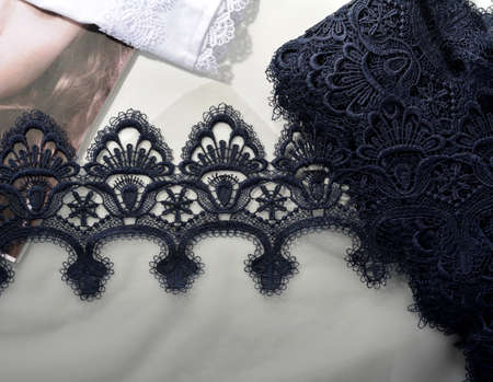 Tapes of blue gentle guipure, beauty silk lace fabric on light background. Elastic material. Using...