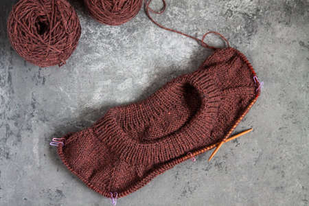 Brown sweater, knitting process, concrete background. Raglan needles. woolen weave threads.の写真素材