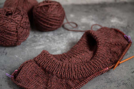 Brown sweater, knitting process, concrete background. Raglan needles. woolen weave threads.の写真素材