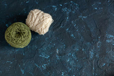 Color balls skein of wool yarn for crochet and knit on dark blue texture putty concrete. Flatlay image with space for text.の写真素材