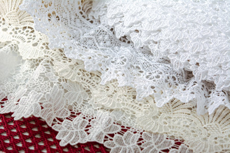 pile of red, white. beige set sail champagne gentle luxury quality guipure, lace fabric on gray...