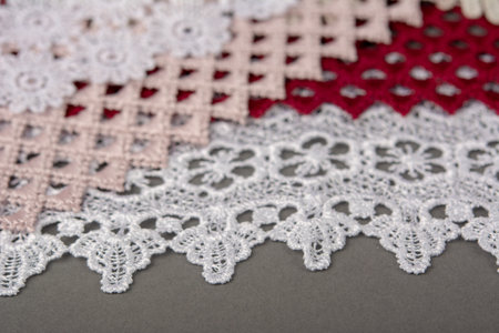 pile of red, white. beige set sail champagne gentle luxury quality guipure, lace fabric on gray background. use for sew clothes linen decoration.の写真素材