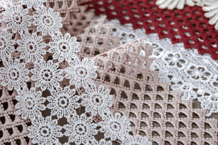 pile of red, white. beige set sail champagne gentle luxury quality guipure, lace fabric on gray background. use for sew clothes linen decoration.の写真素材