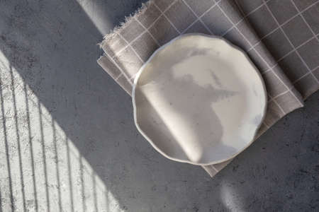Stone curl color white and gray platter on conrete table, top view mockup. Plate Diy made of cement...
