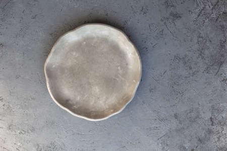 Stone curl color white and gray platter on conrete table, top view mockup. Plate Diy made of cement...
