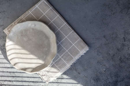 Stone curl color white and gray platter on conrete table, top view mockup. Plate Diy made of cement streaks, scratches and cracks. Space for text. Selective soft focus.の写真素材
