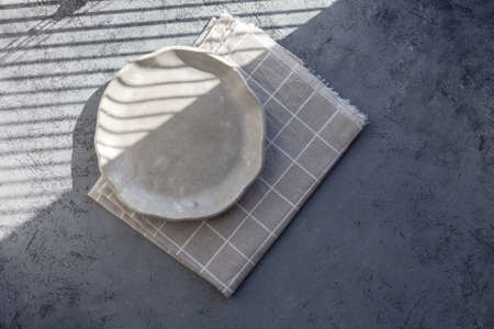 Stone curl color white and gray platter on conrete table, top view mockup. Plate Diy made of cement streaks, scratches and cracks. Space for text. Selective soft focus.の写真素材