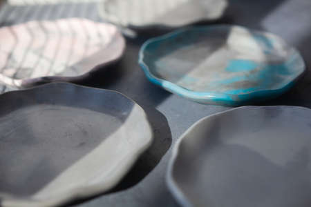 Pile set of Stone curl color platter on gray conrete table, top view mockup. Plate Diy made of...
