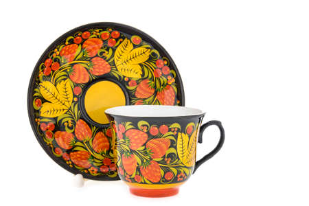 tea pair of Old Traditional Russian folk utensils. Dishes saucer and cup with handmade painting floral ornament in style of Khokhloma isolated on white background.の写真素材