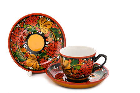 tea pair of Old Traditional Russian folk utensils. Dishes saucer and cup with handmade painting floral ornament in style of Khokhloma isolated on white background.の写真素材