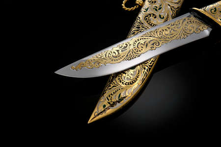 souvenir collectible silver gold dagger cutlass with scabbard, with metal engraving, on black background. Luxury weapons with traditional patterns in medieval vintage style.の写真素材