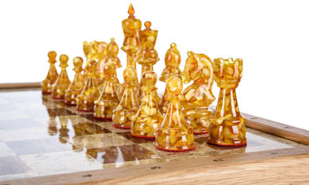 Natural amber different chess pieces figures standing on brown stone board. Close up game concept competition, Classic Gambit Tournament of confrontation.の写真素材