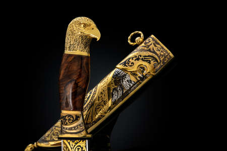 souvenir collectible silver gold dagger cutlass with scabbard, with metal engraving, on black...