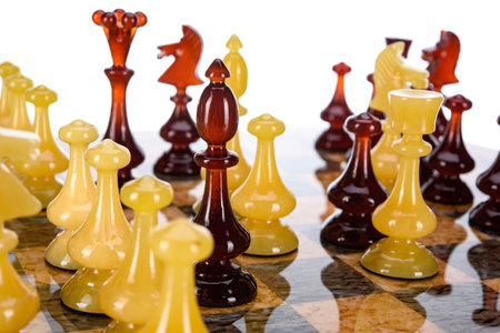 Natural amber different chess pieces figures standing on brown stone board. Close up game concept competition, Classic Gambit Tournament of confrontation.の写真素材