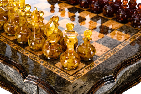 Natural amber different chess pieces figures standing on brown stone board. Close up game concept competition, Classic Gambit Tournament of confrontation.の写真素材