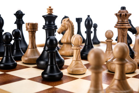 Beige Brown Wooden chess different pieces figures standing on chessboard. Close up game concept competition, Classic Gambit Tournament of confrontation.の写真素材