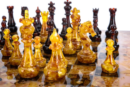 Natural amber different chess pieces figures standing on brown stone board. Close up game concept competition, Classic Gambit Tournament of confrontation.の写真素材
